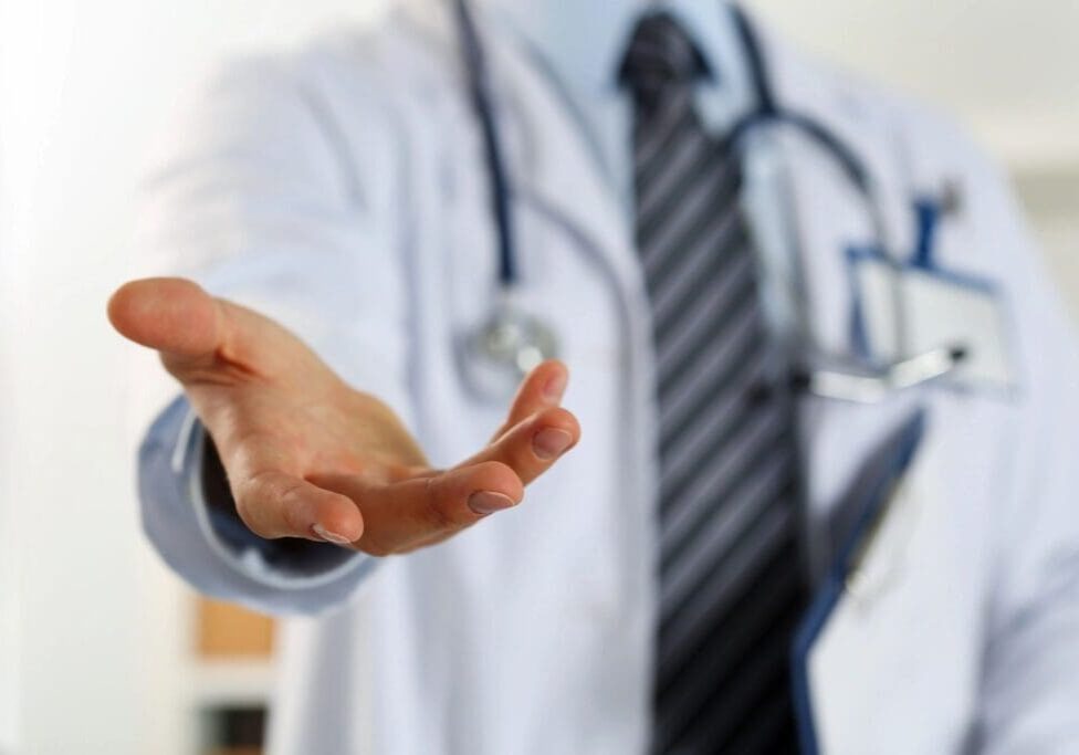 A doctor is holding his hand out to someone.